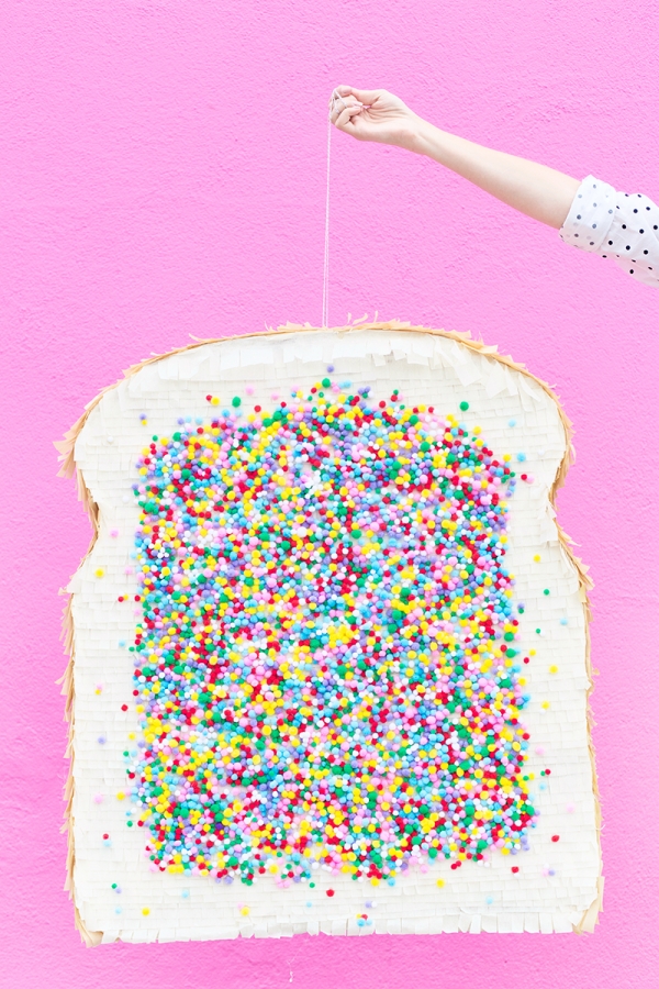 Someone holding a fairy bread pinata 