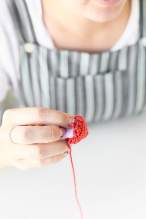 Someone sewing an orange item