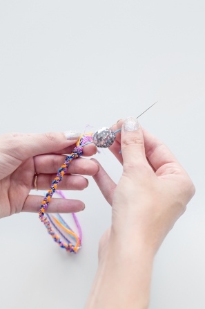 Someone making a friendship bracelet 