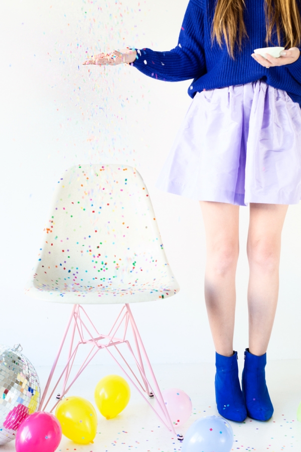 A chair with colorful dots and a person standing next to it