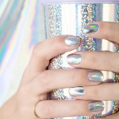 A woman with silver nails holding a silver cup