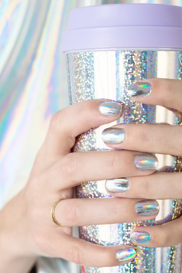 A woman with silver nails holding a silver cup