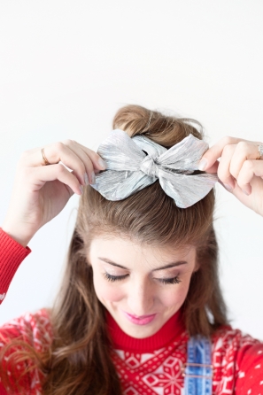 A woman with a silver bowtie in her hair