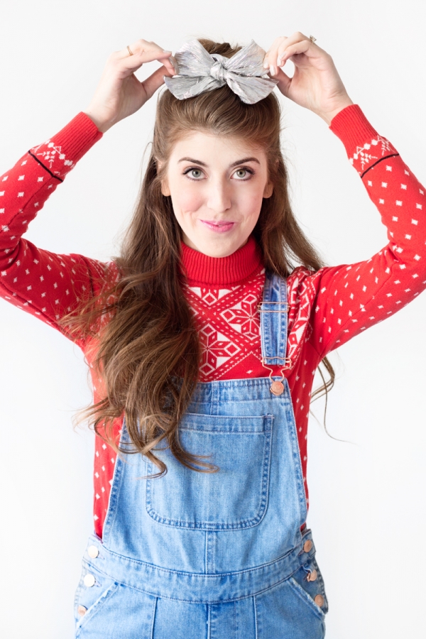 A woman wearing overalls and a red sweater