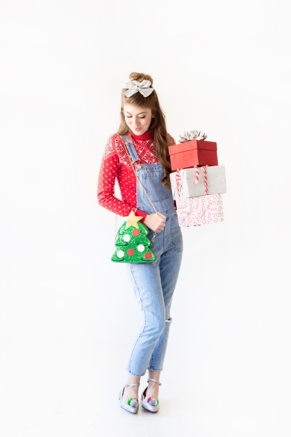 A woman wearing a red shirt and overalls holding presents