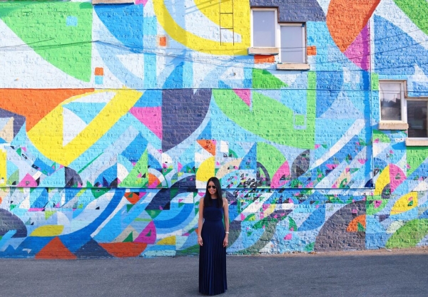 A woman standing in front of a colorful wall