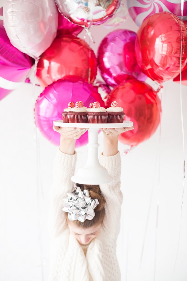 A woman holding a plate of cupcakes