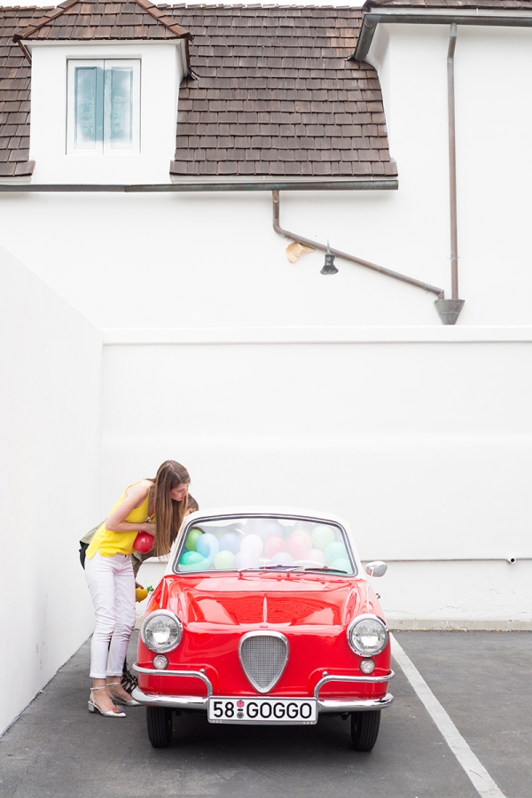 A car filled with balloons and a woman 