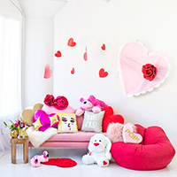 A couch with pillows and hanging hearts