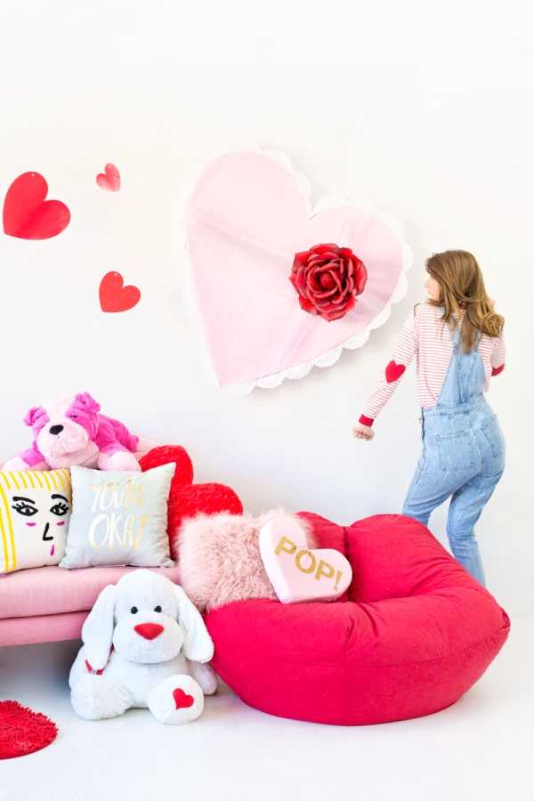 A couch with pillows and a wall with hearts and roses