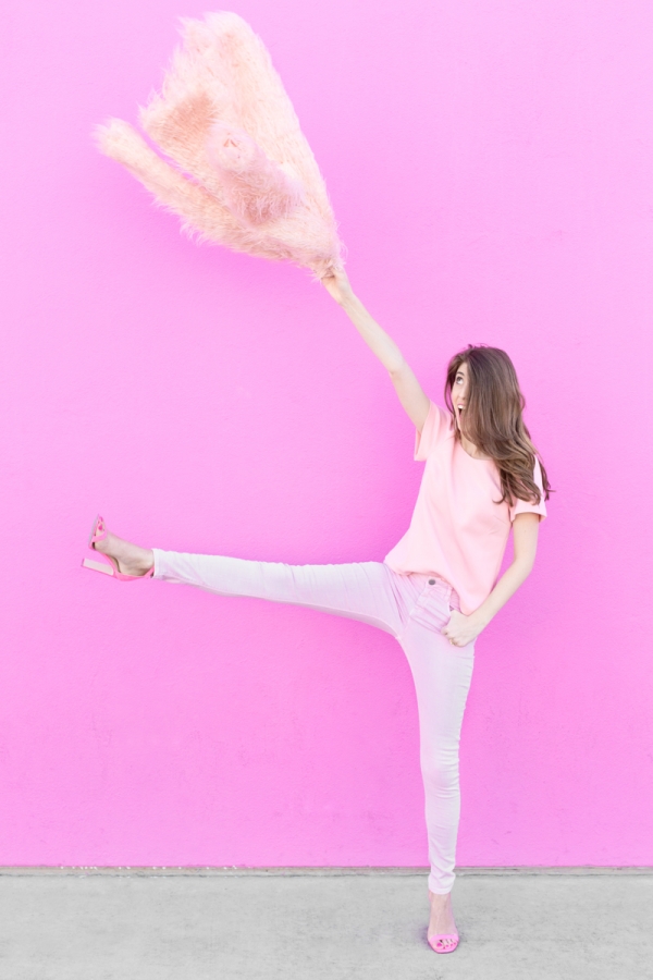 A woman wearing all pink in front of a pink wall