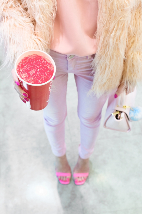 A woman wearing pink pants and holding a pink drink