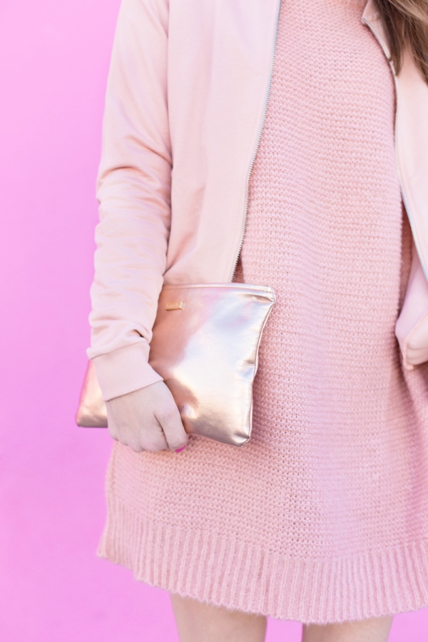 A woman wearing a pink outfit and holding a pink bag