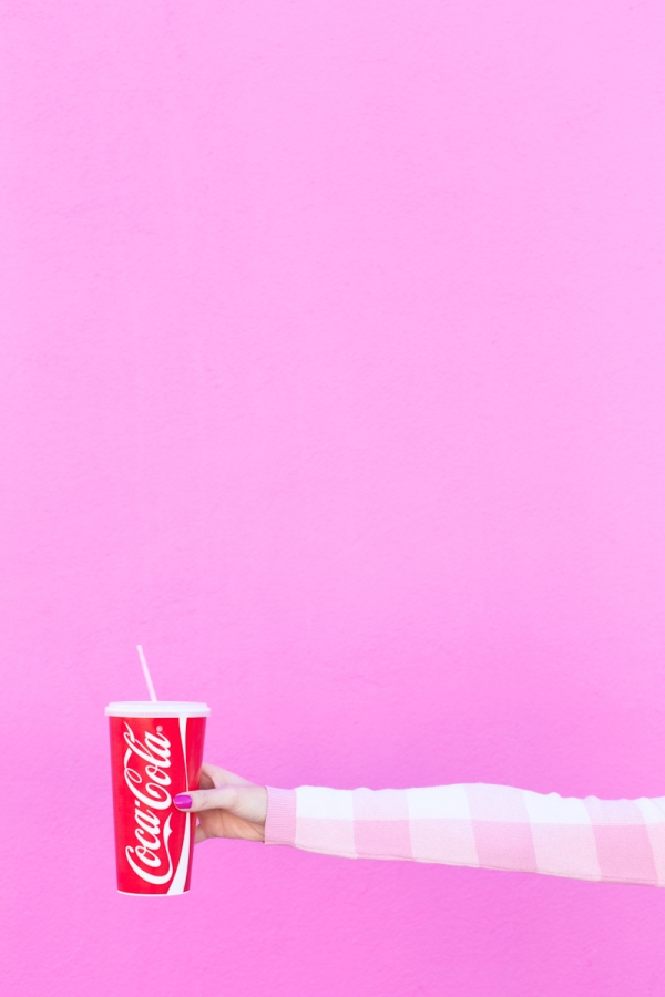 A woman holding a coca cola cup