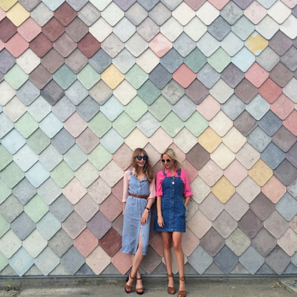 Two girls standing in front of a patterned wall
