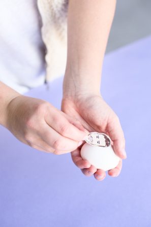 Someone holding an egg and a face sticker