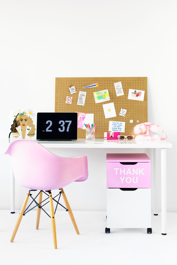 A desk with a pink chair and drawers 