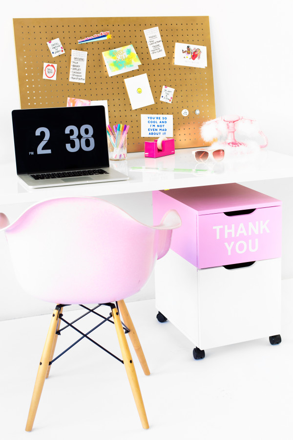 A desk with a pink chair and a computer