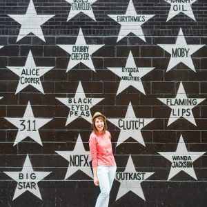 A woman standing in front of a wall with stars on it