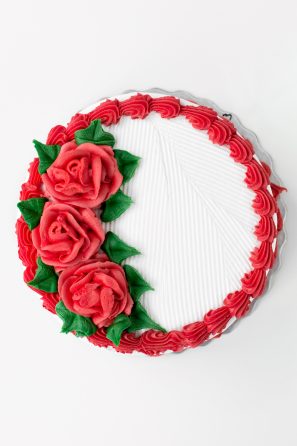 A cake with red frosted flowers on it