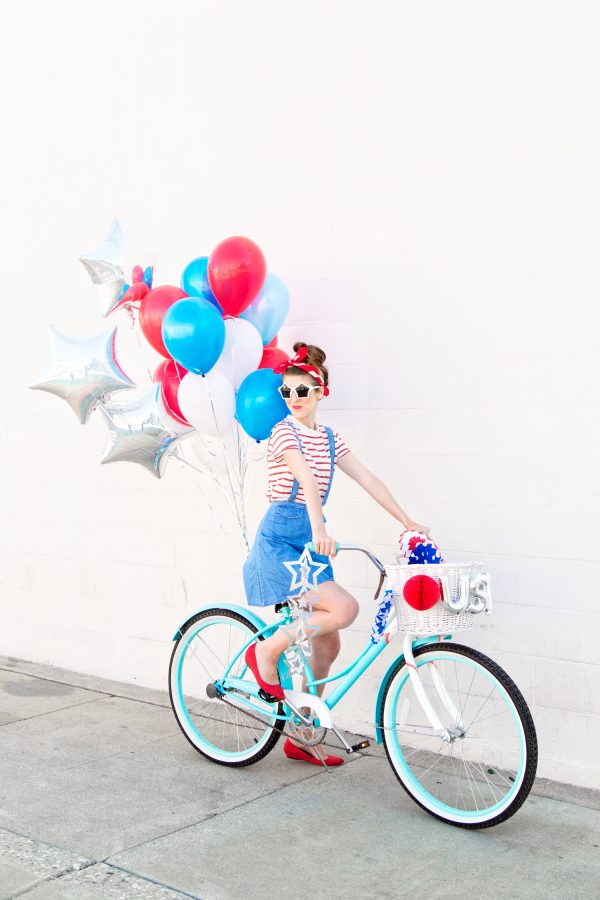 A woman riding a bicycle with colorful balloons