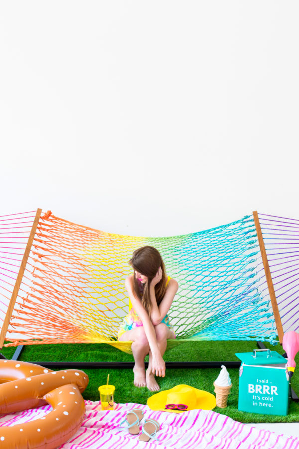 Someone sitting on a rainbow hammock