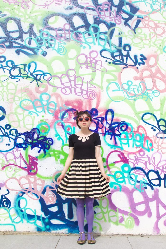 Someone standing in front of a graffiti wall
