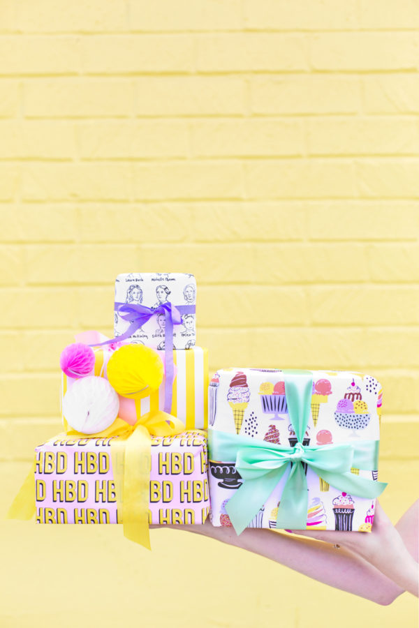 Colorful presents in front of a yellow wall