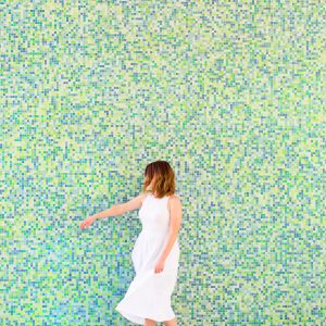 A woman in front of a colorful wall