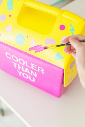 Someone painting a cooler pink and yellow