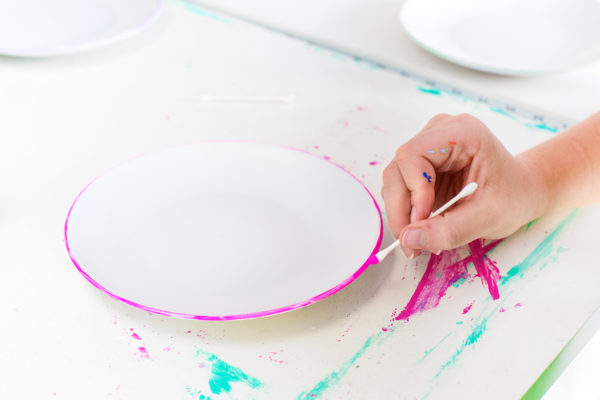 Someone painting a plate