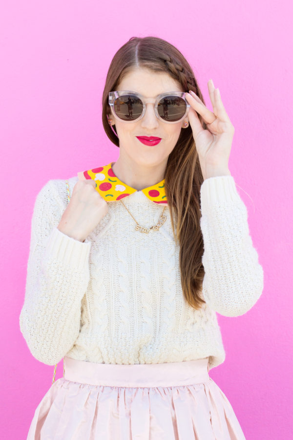 A woman wearing a pizza collar and sunglasses