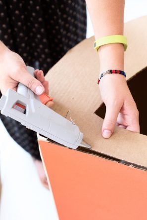 Someone gluing cardboard