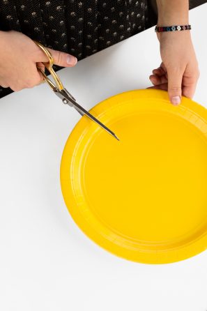 Someone cutting a yellow plate