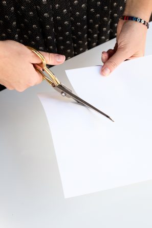 Someone cutting a white paper