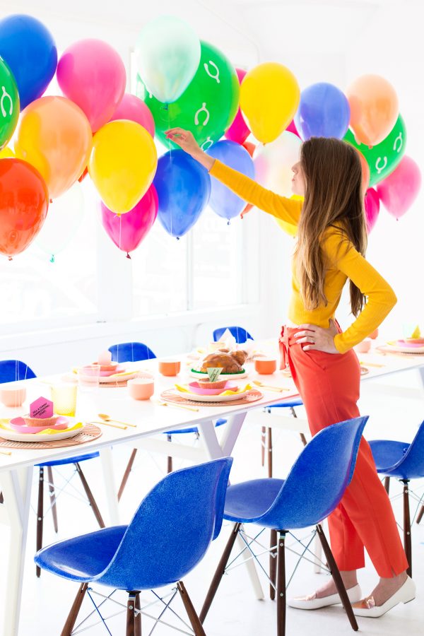 A person near a table and balloons