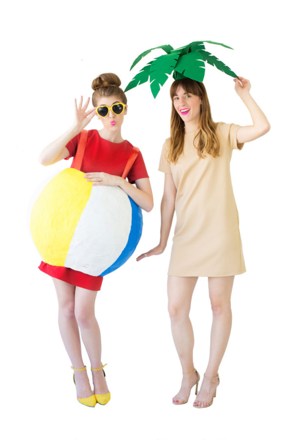 A woman wearing a beach ball costume and another woman wearing a palm tree costume 