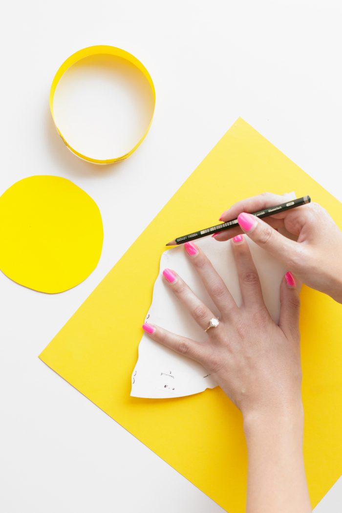 Someone cutting something on yellow paper