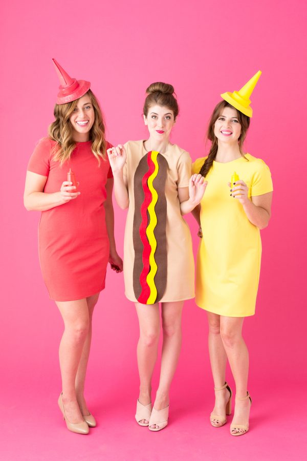 Three people dressed as a hot dog, ketchup, and mustard.