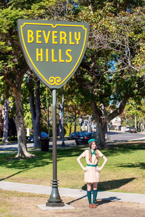 A person standing under a beverly hills sign