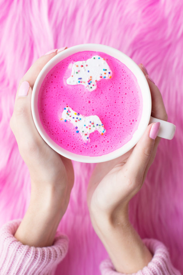 Someone holding a mug with a pink substance in it