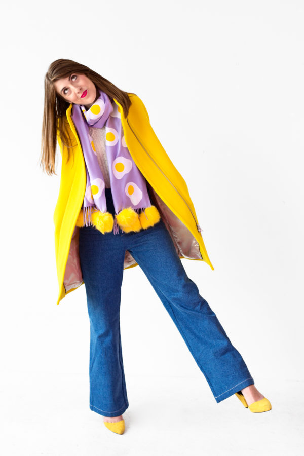A person wearing a purple scarf and yellow jacket