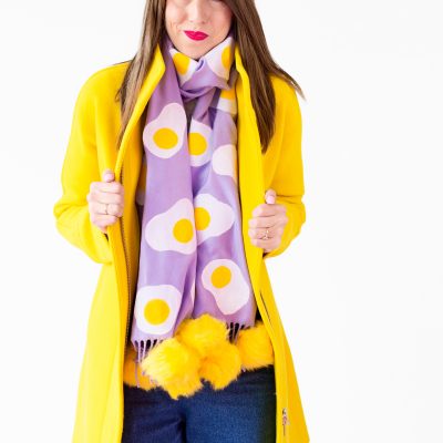 A woman wearing a purple egg scarf and yellow jacket