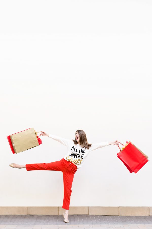 A woman holding red and beige bags 