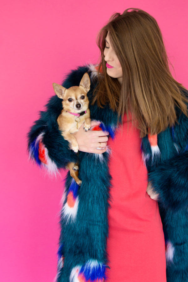 A woman wearing a red dress and holding a dog