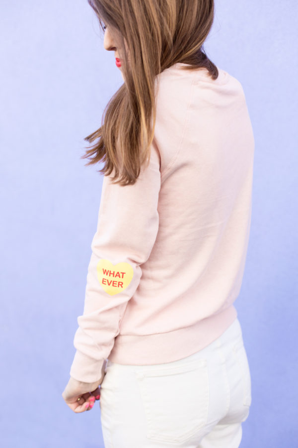 A pink crewneck with heart patches