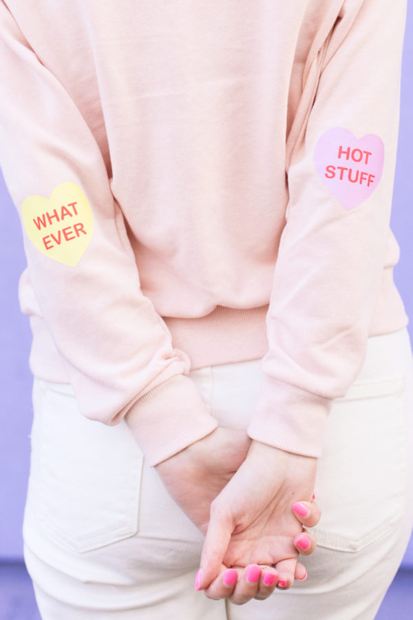 A pink crewneck with heart patches 