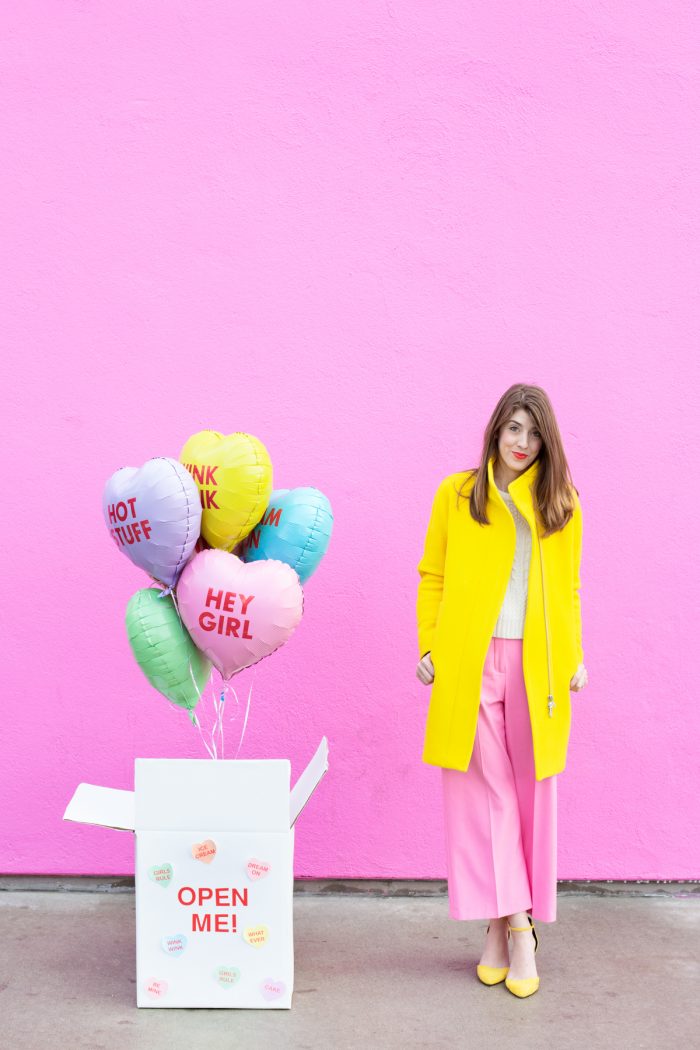 A woman standing next to a box of balloons
