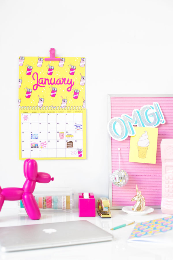 A desk with a yellow calendar and accessories 