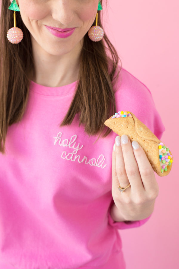 Someone holding a cannoli 